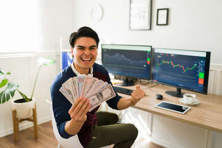 Successful man screaming with happiness while earning a lot of money for investing in the stock...