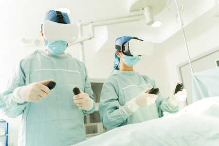 Surgeons at the operating room using controllers and virtual reality glasses while performing...