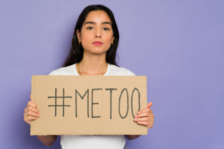 Me too movement. Serious hispanic woman joining the women's movement against sexual abuse in the workplaceの写真素材