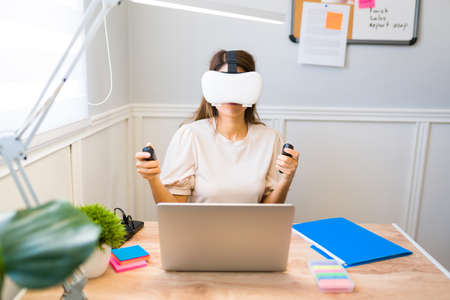 Professional woman wearing virtual reality glasses and using immersive technology for her...