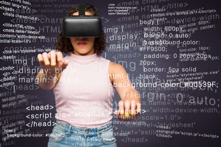 Futuristic young woman coding while wearing virtual reality glasses and using the cyberspace in the...