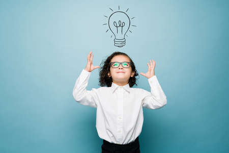 Smart boy having a clever idea while playing businessman and using his imagination against a...