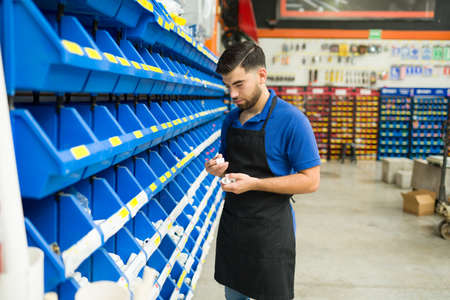 Attractive young man and worker at the hardware store looking for a tool or new pipes in the piping aisleの写真素材