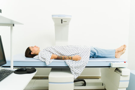 Profile of a sick young woman at the medical lab doing a densitometry scan test to to get a bone diagnosisの写真素材
