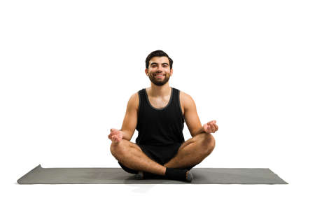 Cheerful relaxed man doing a yoga pose and ready for a relaxing meditation and breathing exercisesの写真素材