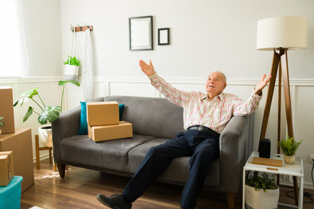 Cheerful excited elderly man feeling very happy enjoying his new home or apartment after movingの写真素材