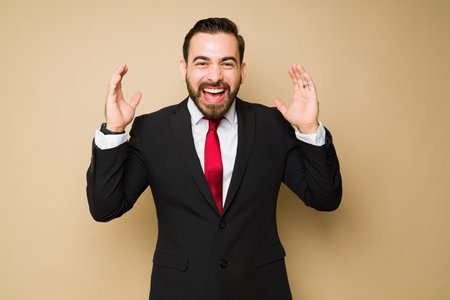 Excited businessman or salesman looking cheerful and surprised while workingの写真素材