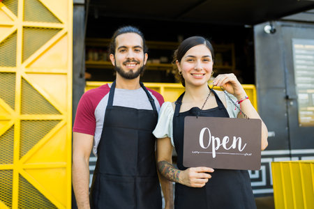 Cheerful stall vendor and cook smiling after opening the fast food truck