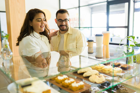 Attractive couple dating and buying a muffin or dessert together at the coffee shopの写真素材
