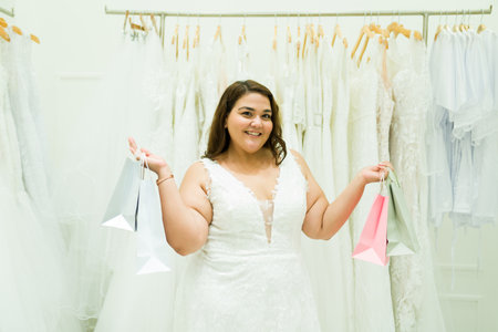 Happy obese latin woman at the bridal store shopping for nuptial accessories and a wedding dressの写真素材