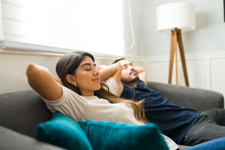 Beautiful woman and man looking relaxed resting together and relaxing on the sofa