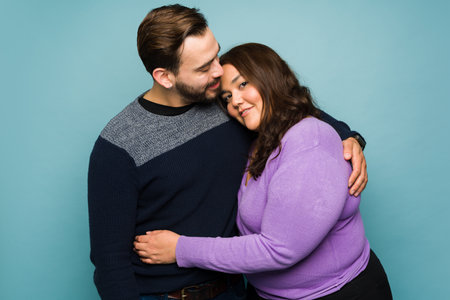 Attractive young couple in love hugging or embracing looking romantic while datingの写真素材