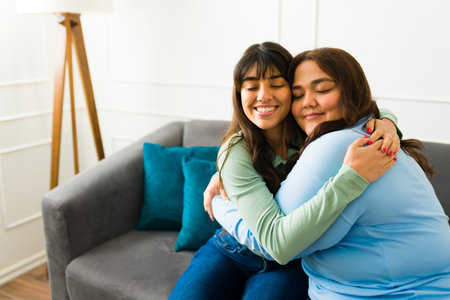 Latin women best friends hugging with her eyes closed while relaxing and hanging out after talking...