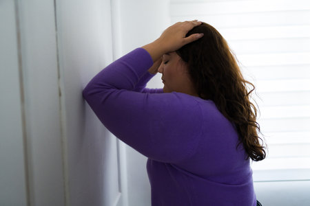Stressed obese woman feeling anxious and depressed with her hands on the head having a lot of mental health problemsの写真素材