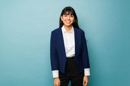 Mexican beautiful business woman looking happy smiling while wearing a formal suit to go to workの写真素材