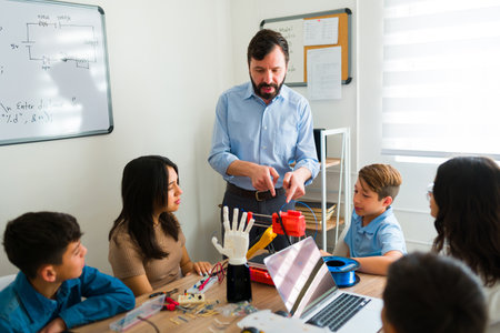 Group of smart teens building robots and learning during a programming course with an hispanic teacherの写真素材