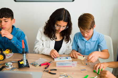 Caucasian boy and latin girl learning how with an electronic circuit works while building a...