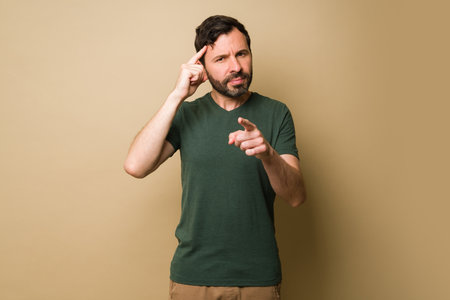 Smart man pointing to his head and asking to make a good decision or thinking about a new idea while pointingの写真素材
