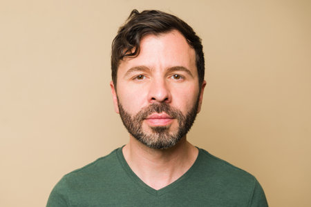 Portrait of an attractive caucasian mid-adult man in his 40s with a beard making eye contact against...