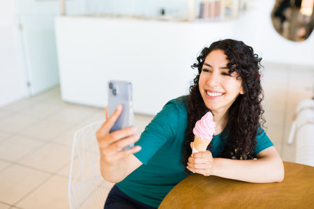 Excited young woman using her smartphone and taking a selfie for social media after buying an ice...