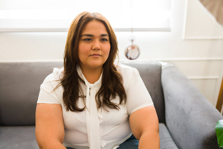 Latin woman at the therapist office trying hypnosis with a clock while getting help with her depression with a psychologistの写真素材
