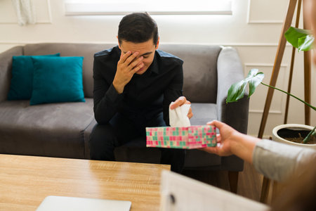 Depressed man in mourning talking about his grief and crying  after his partner or friend passed...