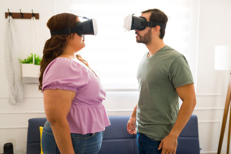 Attractive couple wearing augmented reality glasses for a virtual date and using technology for a...
