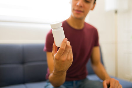 Attractive young man holding a hand cream lotion or mock-up product with copy space designの写真素材