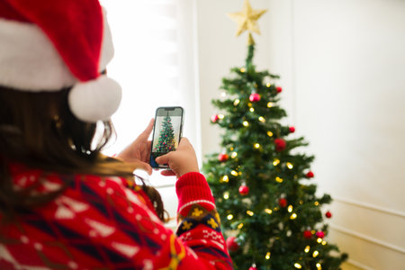 Plus size hispanic woman with a santa hat seen from behind taking a picture of her beautiful...