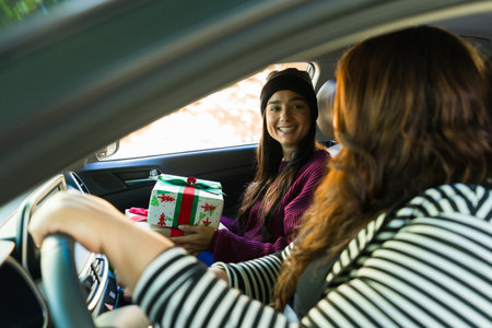 Gorgeous latin woman and her best friend driving the car in the winter holidays while going shopping...