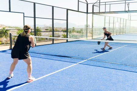 Sporty women practicing and training padel tennis outdoors while playing a match at the tennis courtの写真素材
