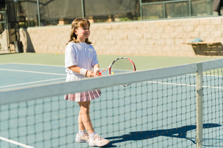 Happy caucasian girl smiling while having fun taking tennis lessons and playing a game with a racketの写真素材