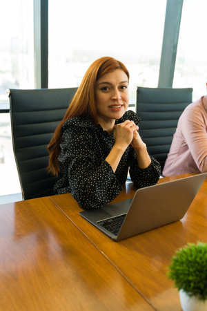 Attractive businesswoman making eye contact while attending a business meeting in an officeの写真素材