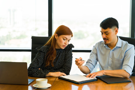 Serious businesswoman carefully reading a contract before closing a deal with a partnerの写真素材
