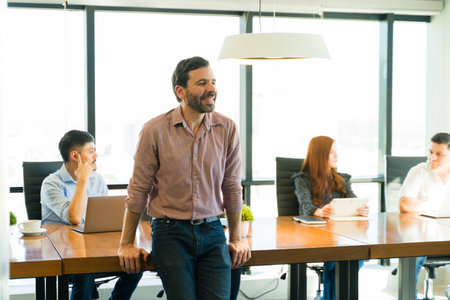 Good looking businessman relaxing and smiling while attending a business meeting