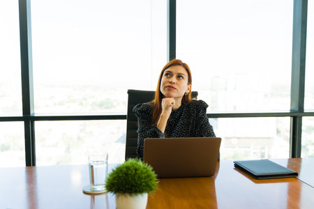 Portrait of a Caucasian businesswoman looking up towards copy space while working in an office