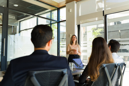 Pretty Caucasian businesswoman joking around with her colleagues during a team meeting