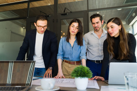 Group of four architects working on an architecture project in a meeting roomの写真素材