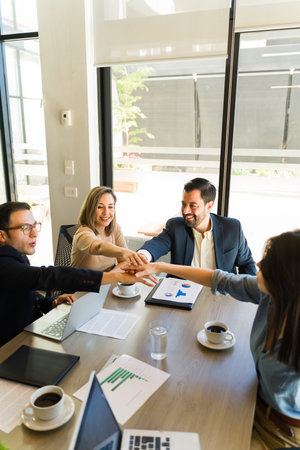 Group of businesspeople bringing hands together as a team during a business meeting