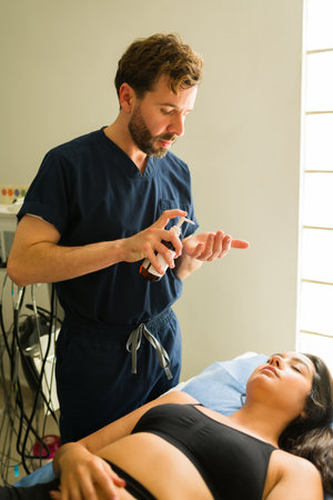 Attractive therapist putting moisturizer to a woman after a beauty treatment or alternative therapy at the health clinicの写真素材