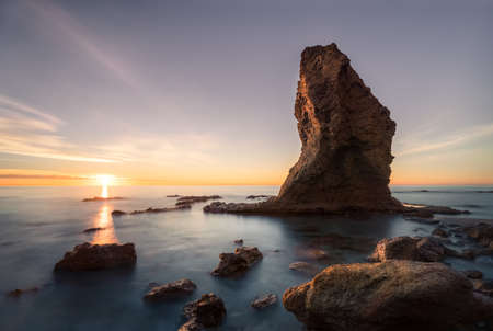 Dawn on this beach between Carboneras and Mojacar, two towns in the province of Almeria (Spain), the rock that stands out seems to resemble a hat perched in the water.の写真素材