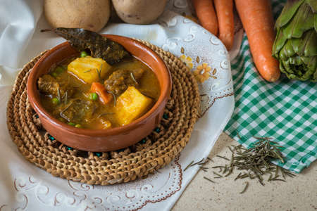 Typical Spanish food, composed mostly of potatoes, peas, carrots, meat, artichoke, etc ...の写真素材