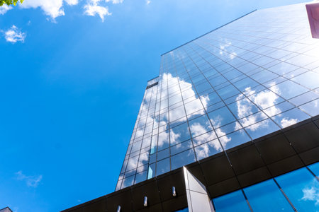 Modern office building skyscrapers with blue sky and cloud reflection.