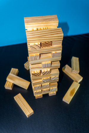 Wooden blocks tower on a blue background. The concept of risk and strategy in business.の写真素材