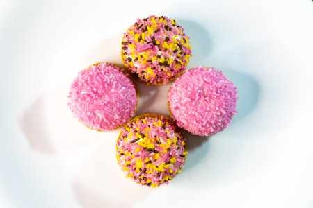 Cupcakes with pink icing on a white background, top view