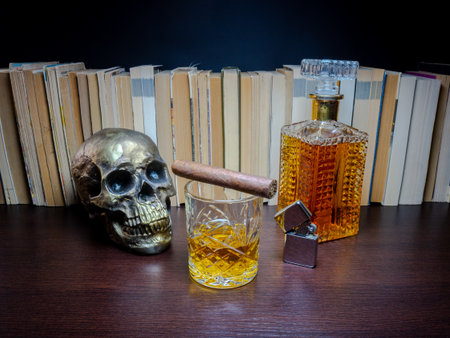 Skull, cigar, whiskey and old books on a dark backgroundの写真素材