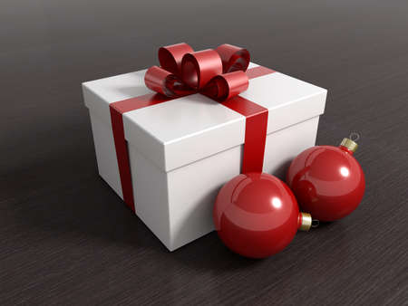 Gift box with christmas balls and a red ribbon on a black wooden floor