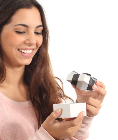 Teen girl smiling opening a gift box in a white isolated background                の写真素材