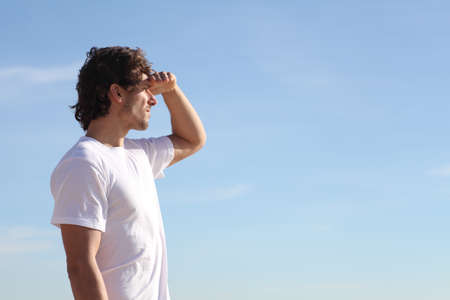 Man watching the sky with his hand in the foreheadの写真素材