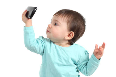 Baby watching concentrated a mobile phone with a white isolated background の写真素材